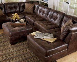 This may contain: a living room with brown leather furniture in it